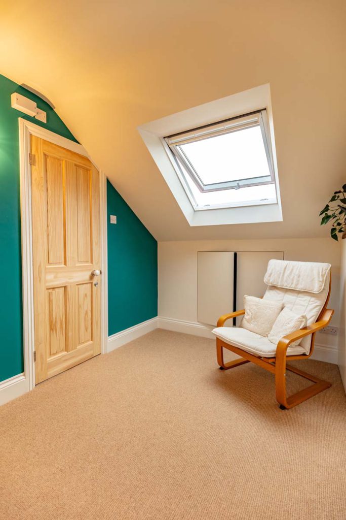 Eaves storage cupboards and a pine door beside the rooflight in a Horfield dormer loft conversion