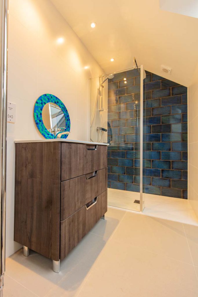 En-suite shower room with blue metro-tiled walk-in shower and dark wood vanity in a Horfield dormer loft conversion
