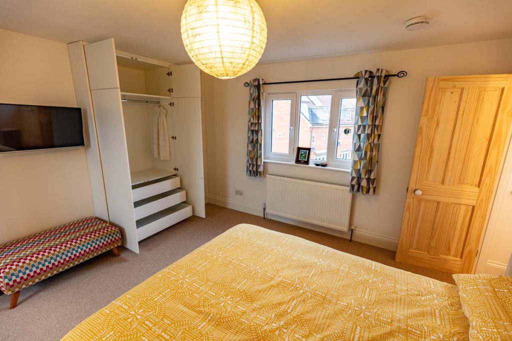 Built-in wardrobe with internal shelving beside the dormer window in a Horfield loft conversion