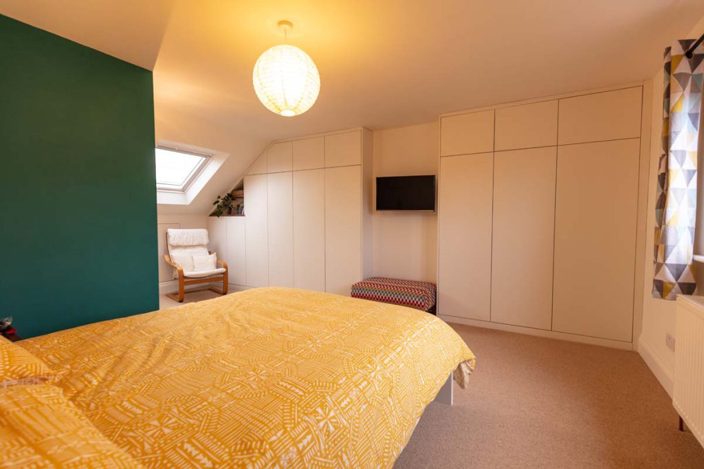 Fitted wardrobes running along the wall and eaves of the bedroom in a Horfield dormer loft conversion