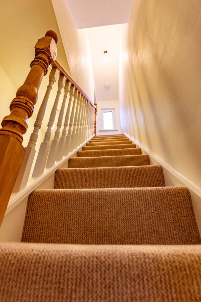 Carpeted staircase rising to the new loft rooms in a Horfield dormer conversion