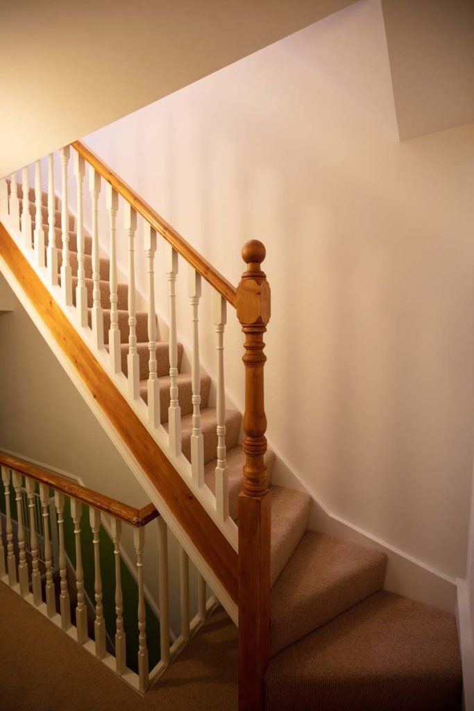 New carpeted staircase with turned pine newel post up to a Horfield dormer loft conversion