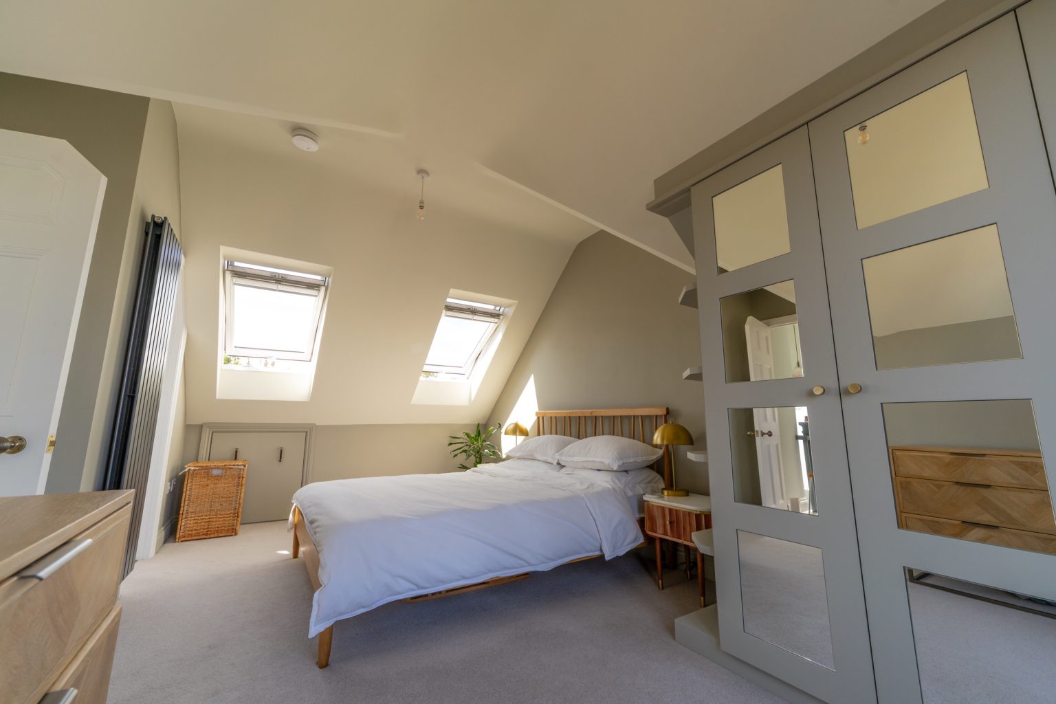 Loft bedroom with bespoke mirrored fitted wardrobes in a Redland dormer loft conversion, Bristol