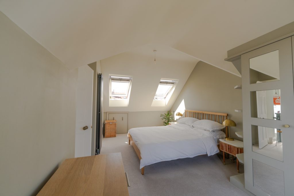 Loft bedroom with a vaulted ceiling and fitted wardrobe in a Redland dormer loft conversion, Bristol