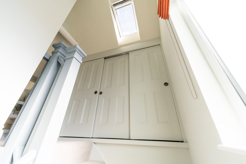 Built-in sliding storage cupboards on the landing of a Redland dormer loft conversion, Bristol