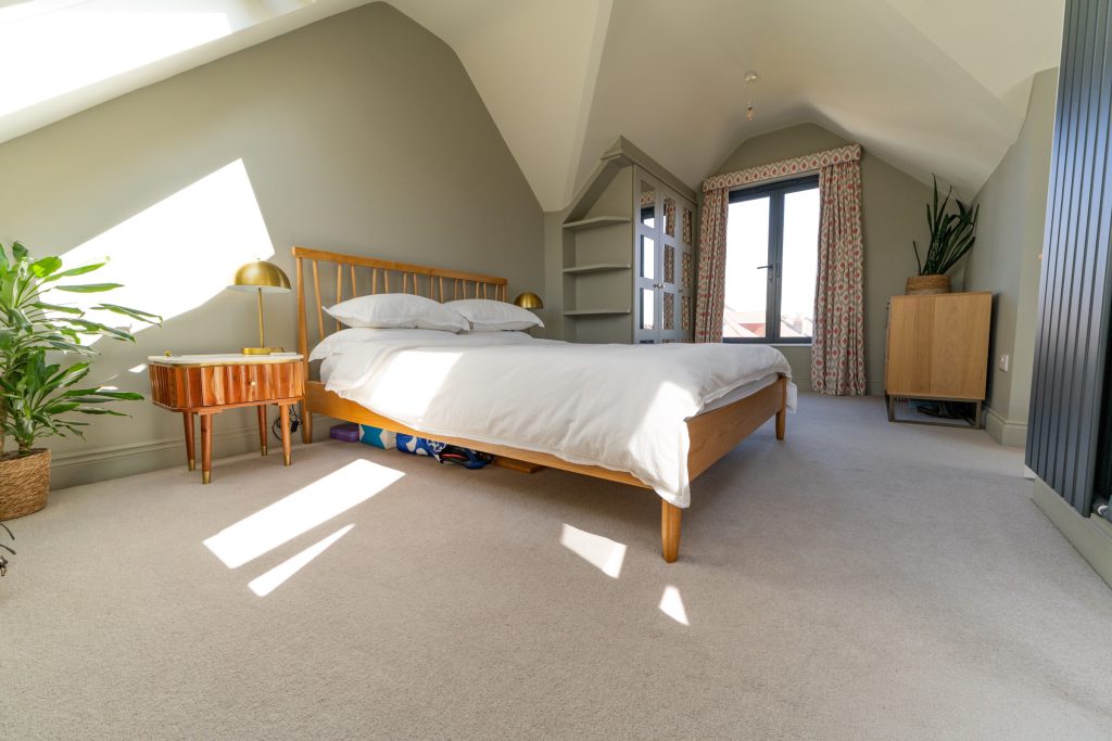 Master bedroom with a vaulted ceiling and French window in a Redland dormer loft conversion, Bristol
