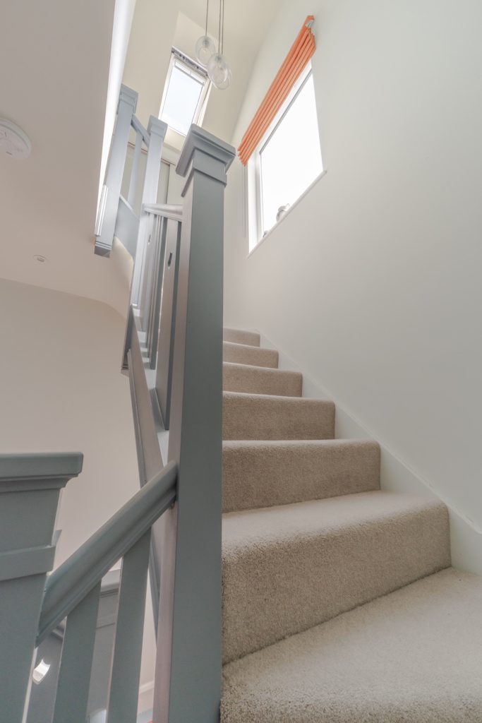 Carpeted staircase rising to the new loft in a Redland dormer loft conversion, Bristol
