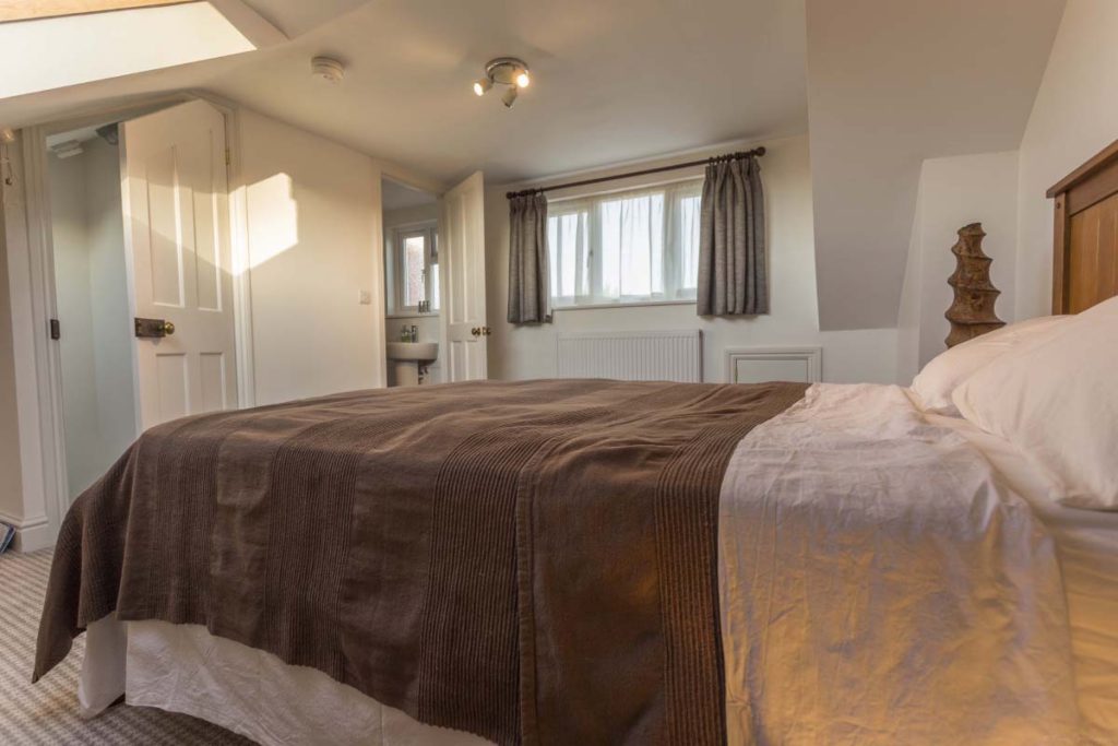Loft bedroom with a dormer window and the en-suite beyond in a St Werburgh's dormer conversion, Bristol