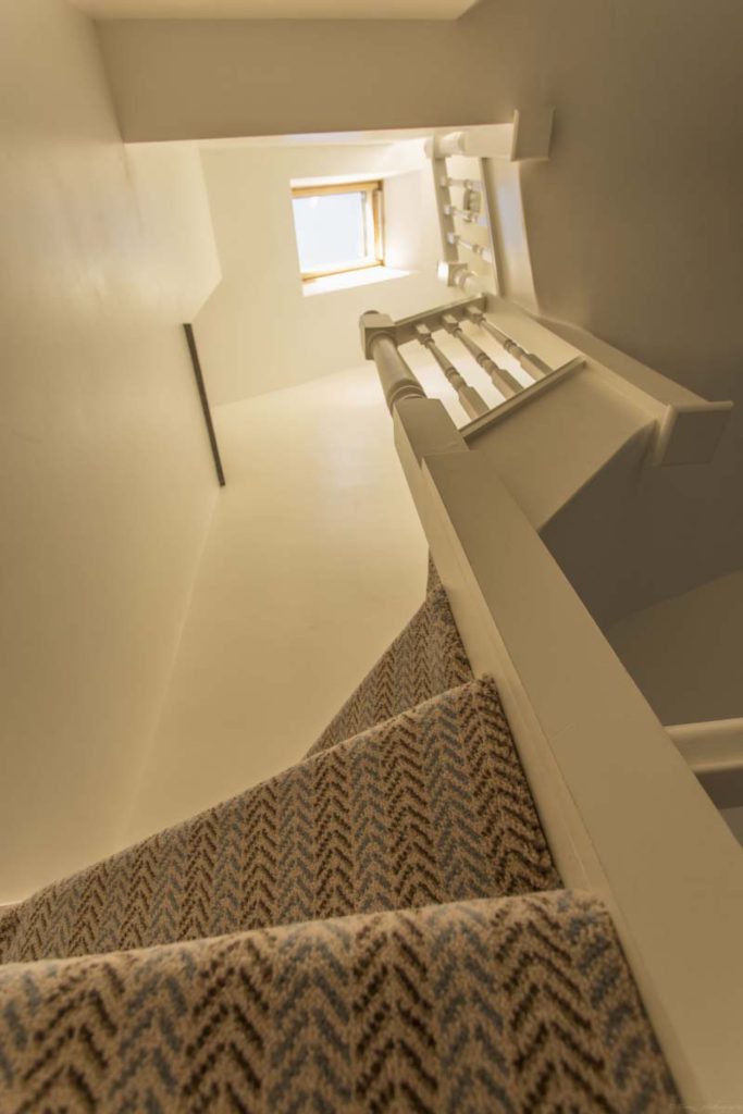 Carpeted staircase rising to the new loft in a dormer conversion in St Werburgh's, Bristol