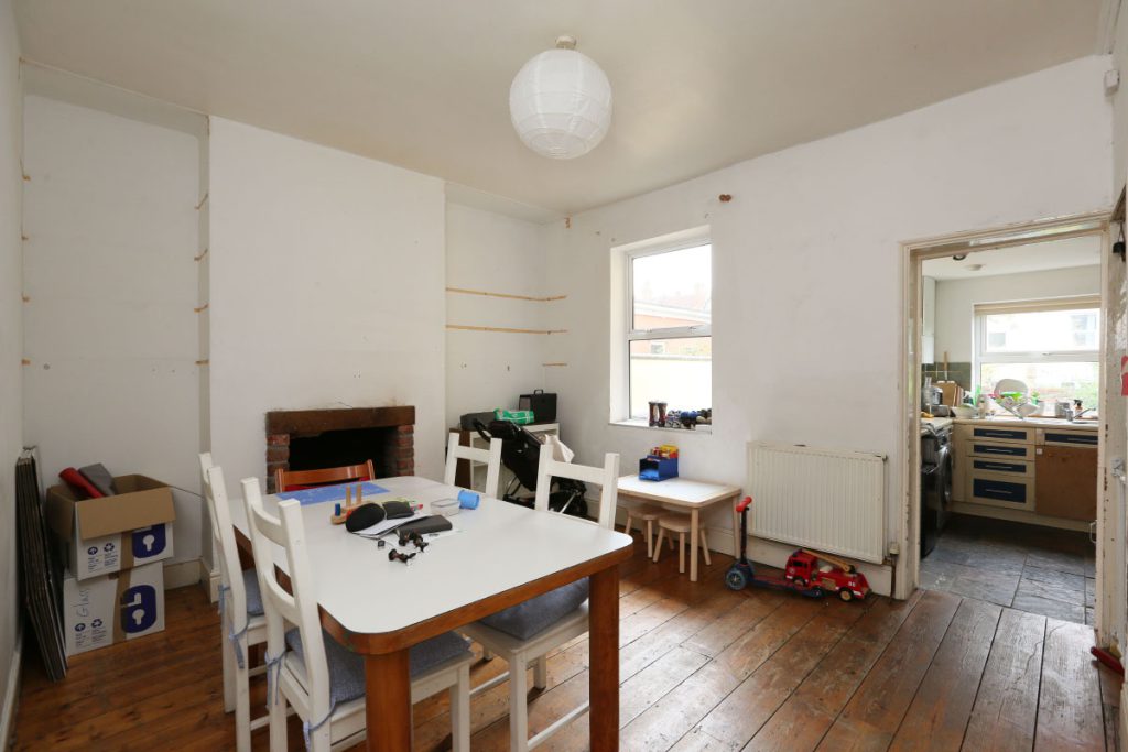 Kitchen-diner before refurbishment, with worn floorboards and dated fittings, in Easton, Bristol