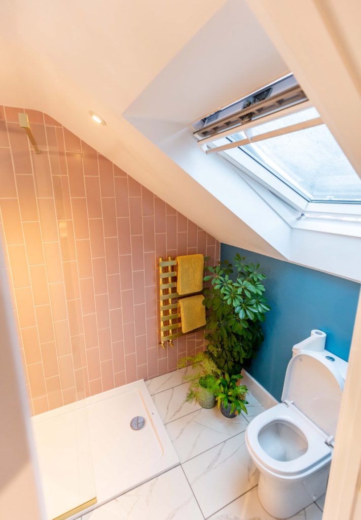 En-suite with terracotta and teal tiling, gold heated towel rail and a rooflight in a Bedminster loft conversion