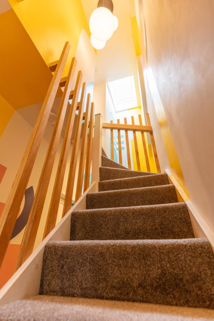 New staircase with a slatted timber balustrade rising to a full-width dormer loft in Bedminster, Bristol