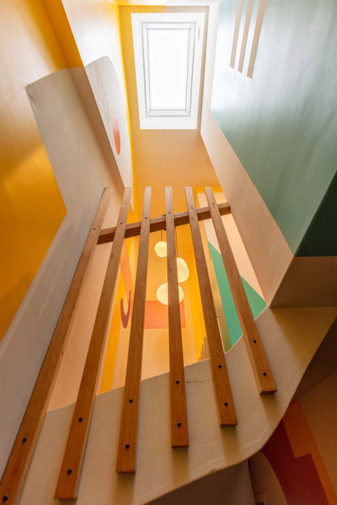 View up the loft stairwell to a rooflight past the slatted timber balustrade in a Bedminster dormer conversion