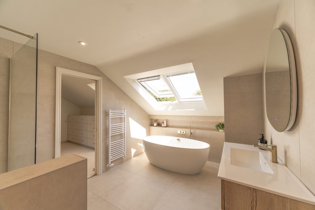 Freestanding bath beneath skylights in the en-suite of a Bishopston hip-to-gable loft conversion, Bristol