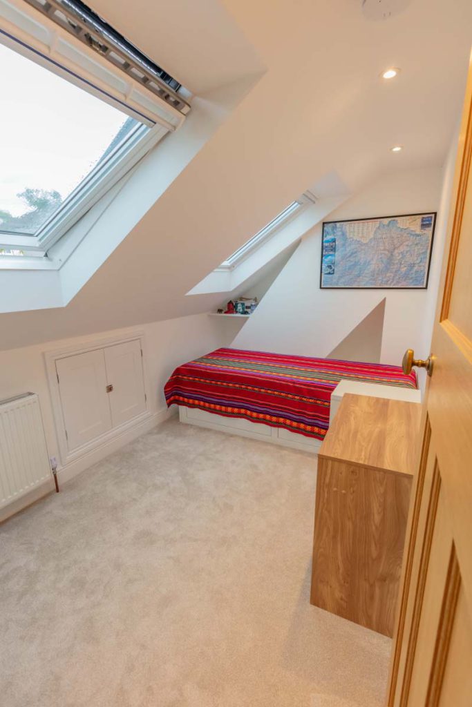 Guest and office room with a single bed under rooflights and built-in eaves storage in a Knowle hip-to-gable loft conversion