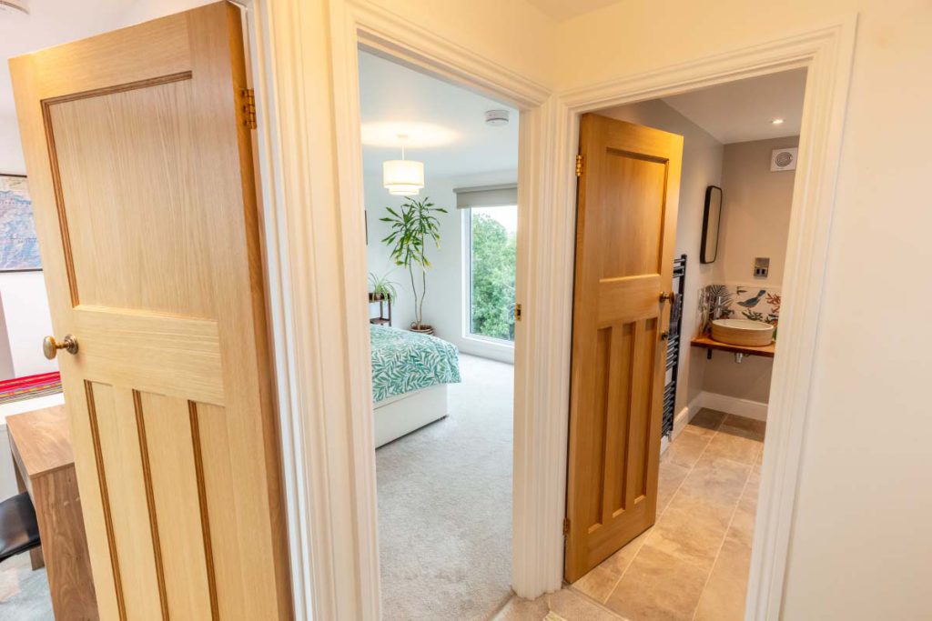 Oak-doored landing linking the master bedroom and shower room in a Knowle hip-to-gable loft conversion
