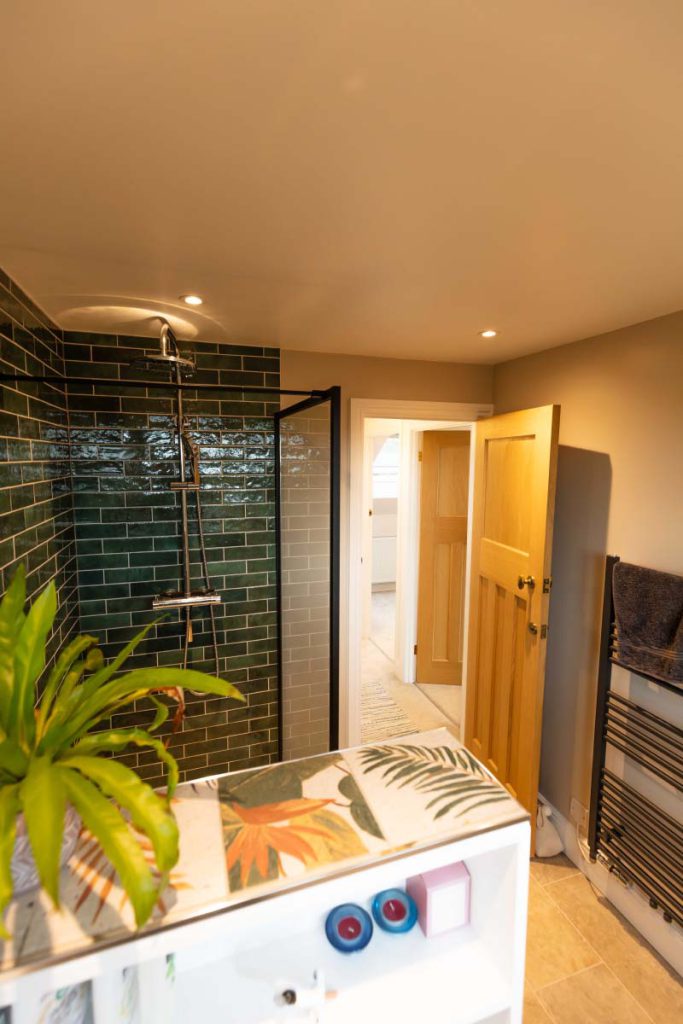 Green metro-tiled walk-in shower with a rainfall head in the large shower room of a Knowle hip-to-gable loft conversion