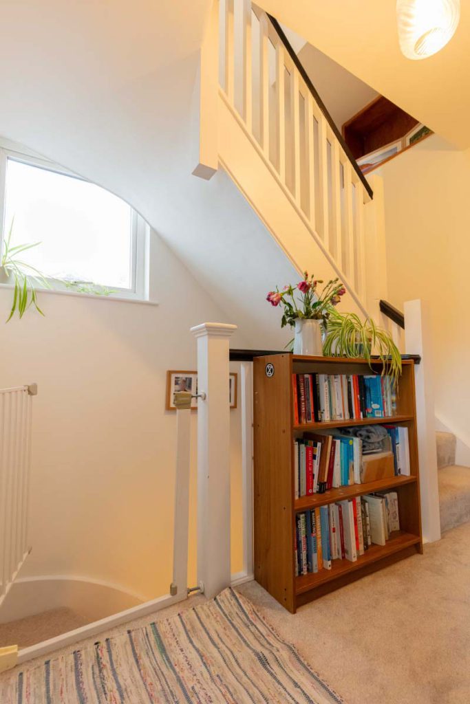 New staircase with an arched window rising to the new loft rooms in a Knowle hip-to-gable loft conversion