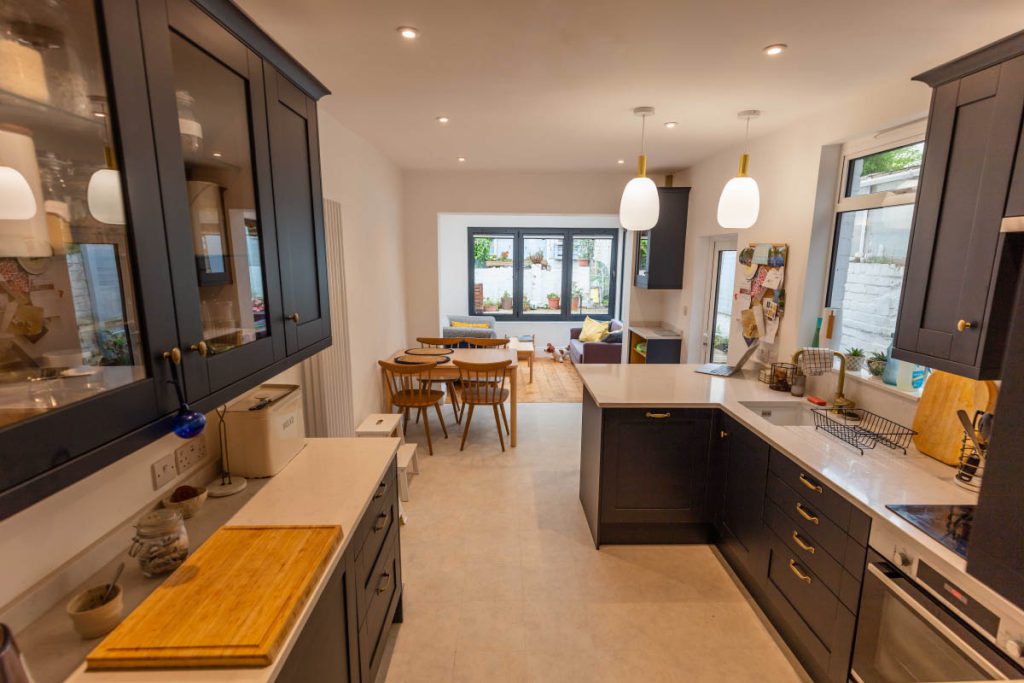 Refurbished open-plan kitchen with navy shaker units and quartz worktops in a house refurbishment in Bedminster, Bristol