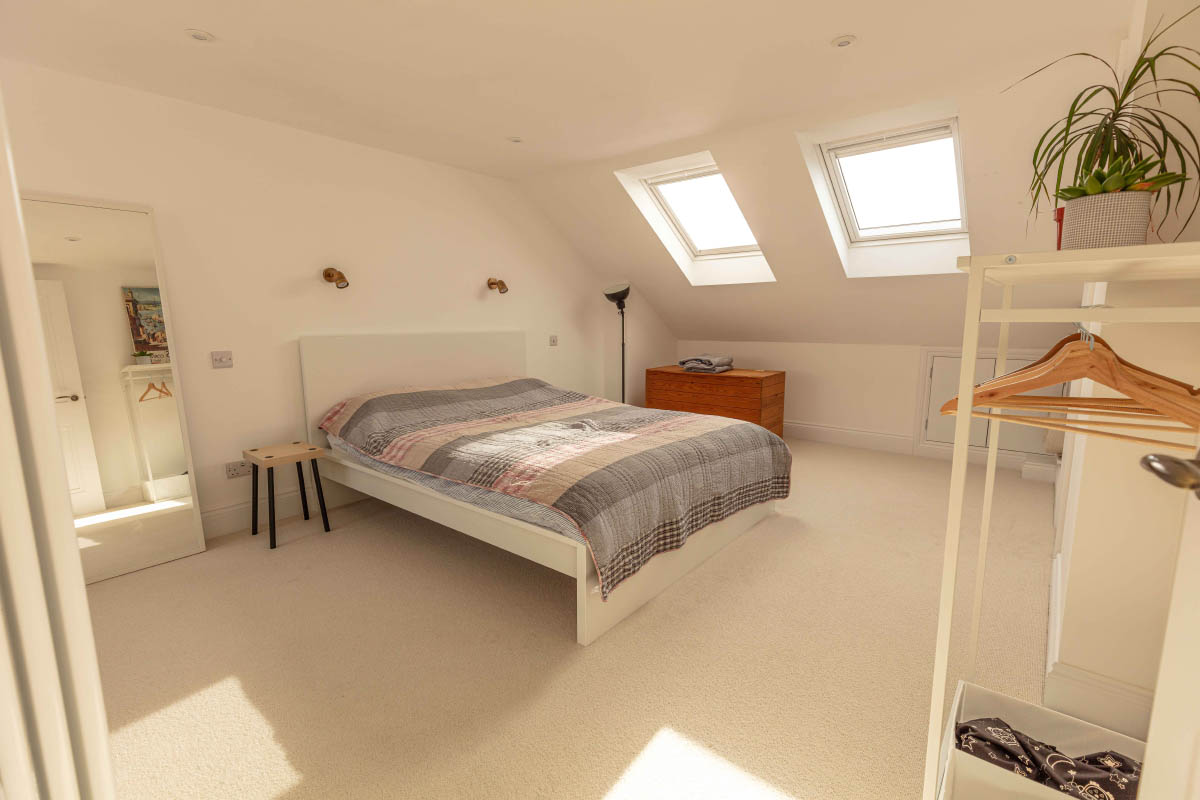 Spacious loft master bedroom with twin rooflights and eaves storage in a large dormer conversion in Bedminster, Bristol