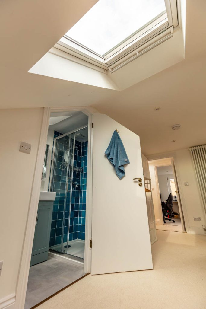 Blue-tiled loft shower room off the landing in a large dormer conversion in Bedminster, Bristol