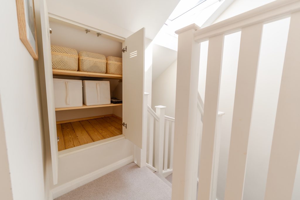 Built-in eaves storage cupboard in the stair section of a low-ceiling dormer conversion in Horfield, Bristol