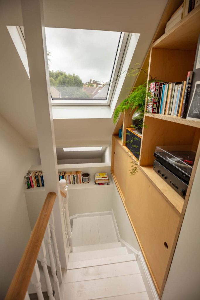 Bespoke plywood bookshelves and record player built into the eaves above the loft stairs in Montpellier