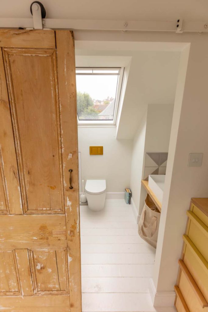 Refurbished Victorian sliding door leading into the en-suite of a Montpellier skylight loft conversion